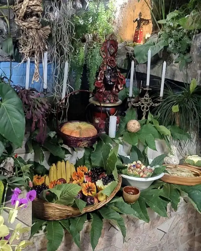 Altar no jardim do Templo, com frutas, velas brancas, folhas e orquídeas